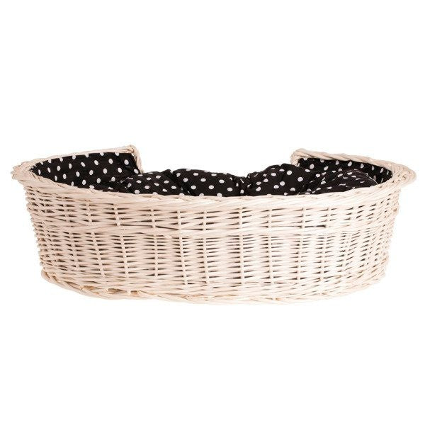 functional whitewashed wicker dog bed with removable cushion in a bright nursery setting