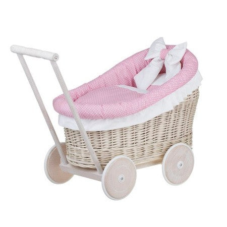 a close-up of the charming whitewashed wicker doll pram with soft pink bedding