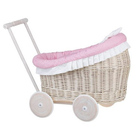 a soft-focus side view of a whitewashed wicker doll pram with cozy pink bedding, bathed in gentle morning light