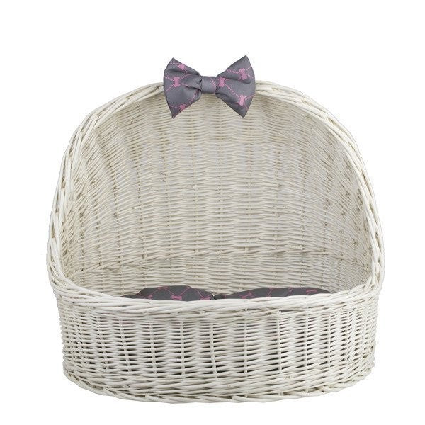 softly lit whitewashed wicker pet house with a plush cushion, a gentle gift for a child's first pet