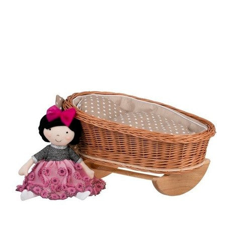functional wicker doll cradle with beige bedding viewed from a practical side angle