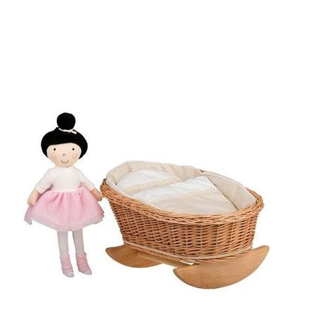 a functional wicker doll cradle with white bedding seen from a low practical angle