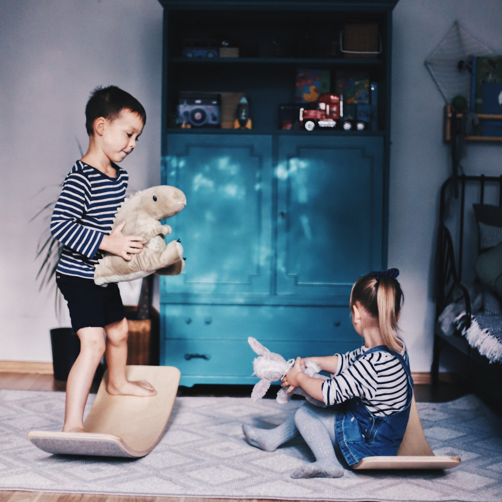 a bold, low-angle shot of a wooden balance board with grey felt, showcasing its powerful curve and minimalist design