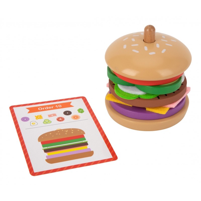 close-up of a child's hands stacking a sustainable wooden burger puzzle on a recipe card
