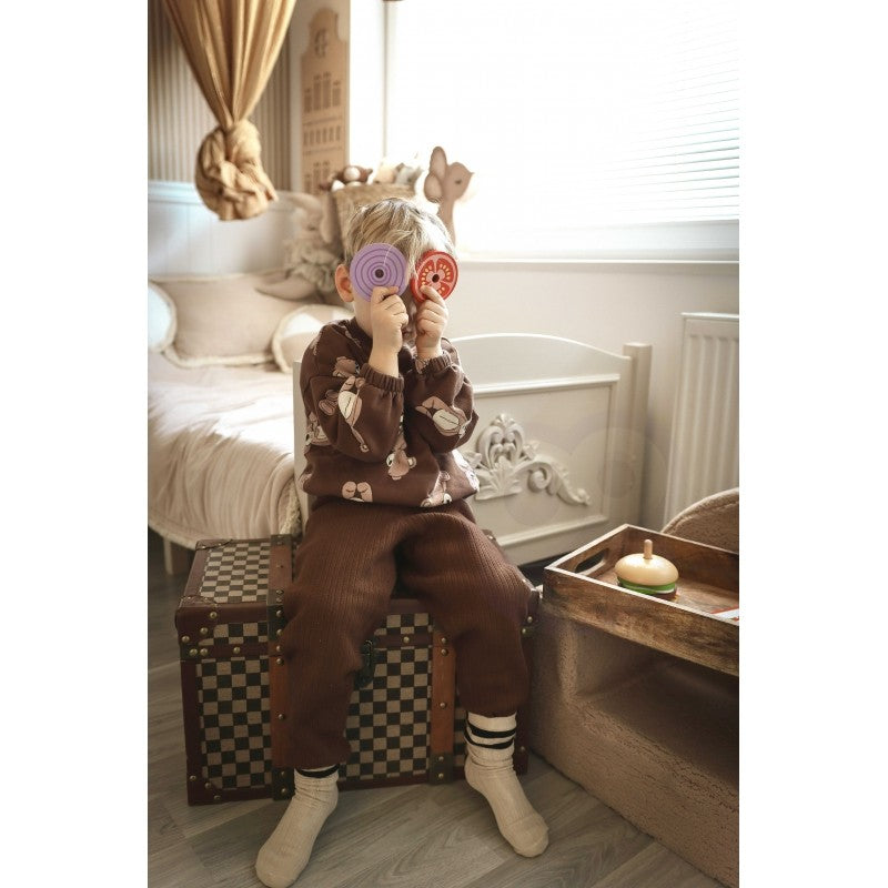 child's hands building a sustainable wooden burger puzzle with lettuce and tomato