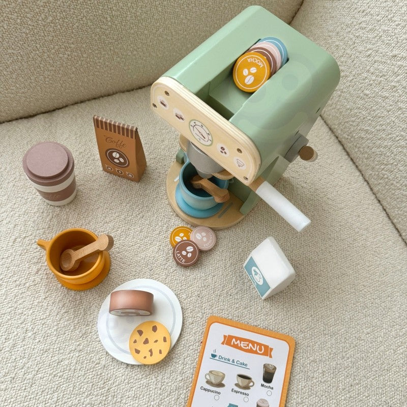 child's hand arranging a wooden coffee cup and pastry on a sunlit table