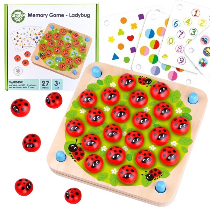 close-up of a child's hands playing with a colorful ladybug memory puzzle on a green grass background
