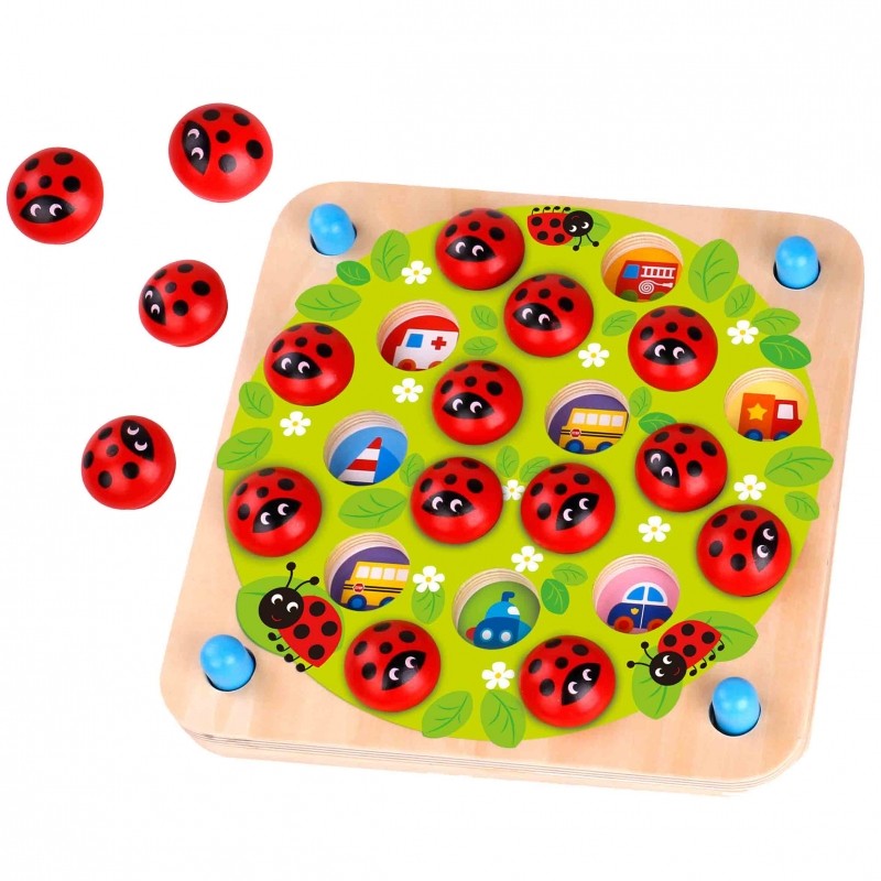 close-up of a child's hands playing with a handcrafted ladybug memory puzzle on a wooden table