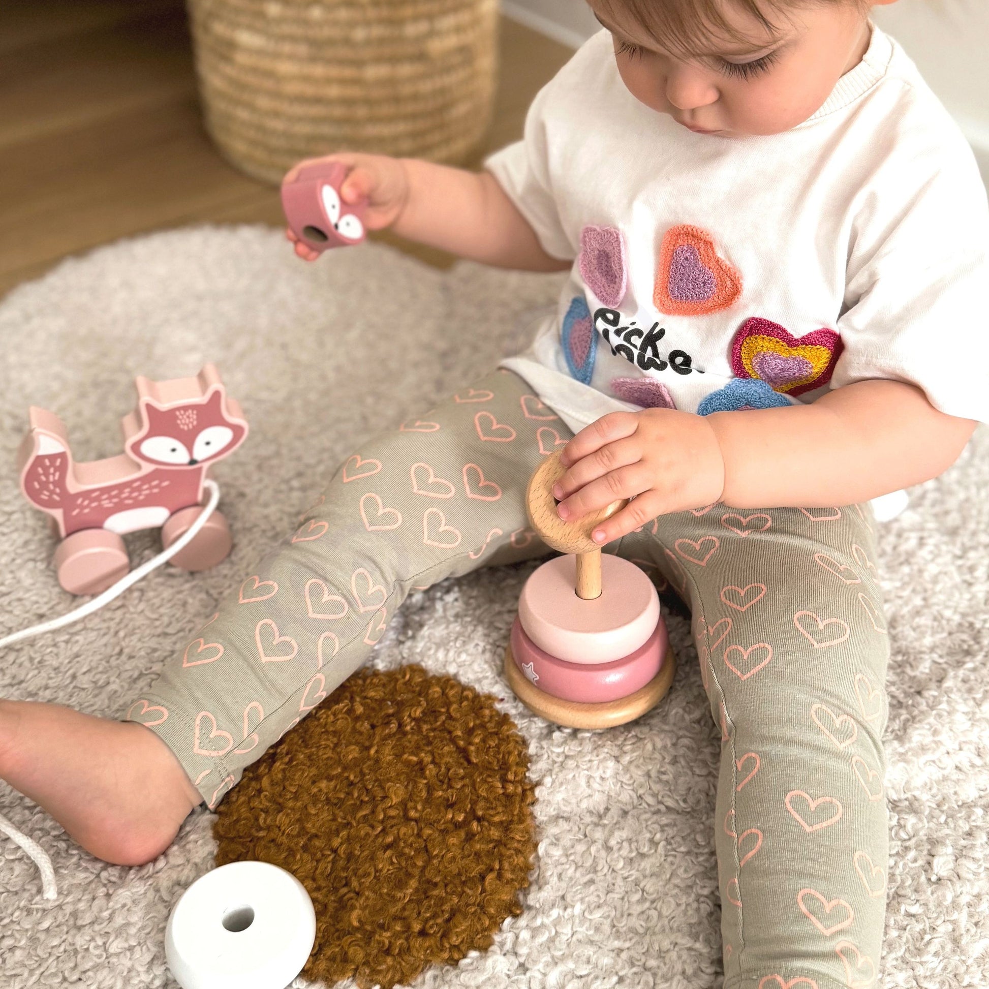 elegant pastel wooden fox pull toy and stacking pyramid on a neutral-toned shelf, showcasing refined toddler play