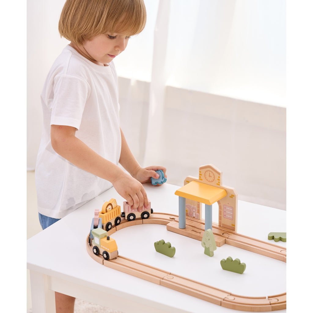 wooden train set with xylophone and threading toys for toddlers, pastel colors on a sunny playroom table